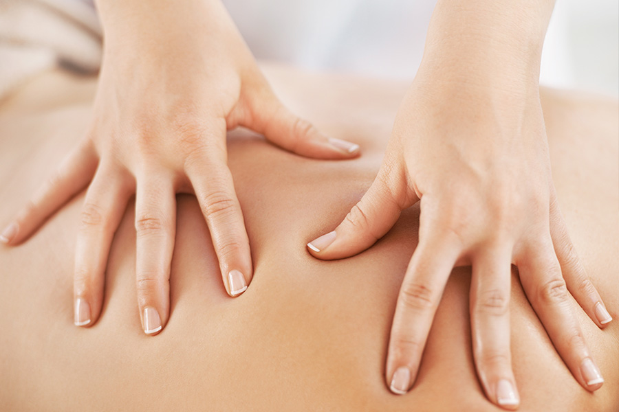 Nahaufnahme der Hände einer Masseurin bei der Arbeit