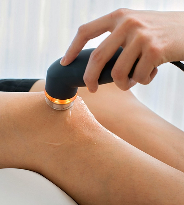 Behandlung mit der Methode der Elektrotherapie am Knie in einer physiotherapeutischen Praxis